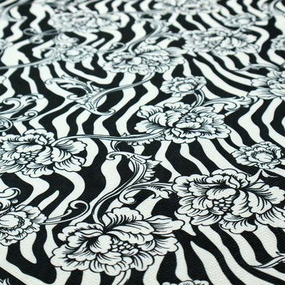 Black and white fabric featuring an ornate floral peony trail layered over a wavy zebra stripe background.   