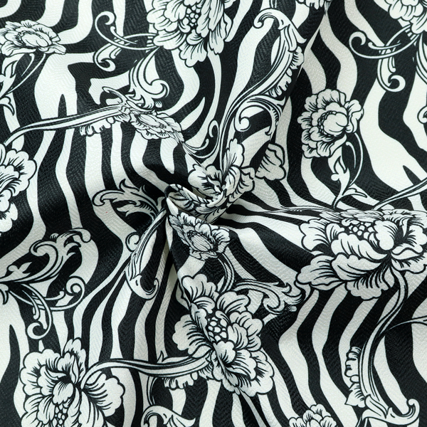 Black and white fabric featuring an ornate floral peony trail layered over a wavy zebra stripe background.   