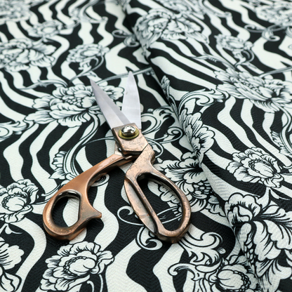 Black and white fabric featuring an ornate floral peony trail layered over a wavy zebra stripe background.   