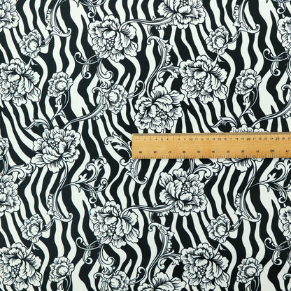 Black and white fabric featuring an ornate floral peony trail layered over a wavy zebra stripe background.   