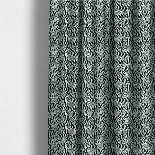 The fabric used to create these made-to-measure curtains is a black and white fabric featuring an ornate floral peony trail layered over a wavy zebra stripe background.   