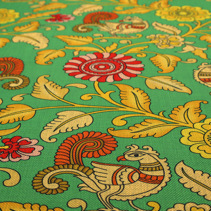 Indian Kalamkari fabric pattern featuring stylized peacocks, golden floral vines, and red rosettes on a vibrant emerald green background.   