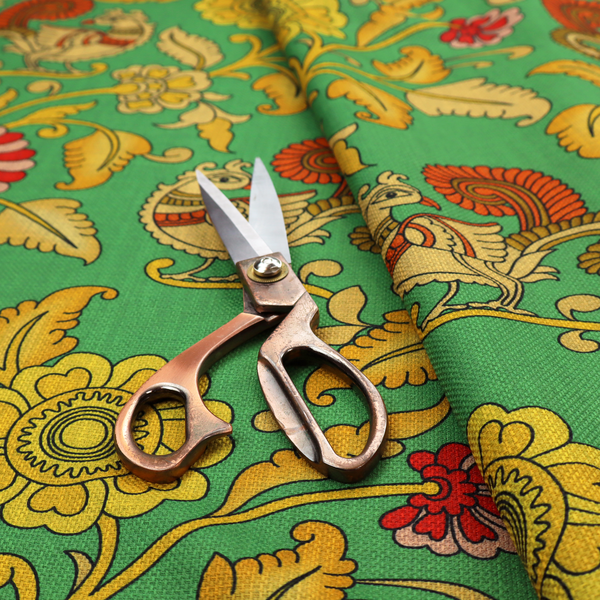 Indian Kalamkari fabric pattern featuring stylized peacocks, golden floral vines, and red rosettes on a vibrant emerald green background.   