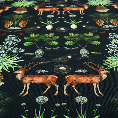 Symmetrical woodland fabric pattern featuring reddish-brown stags with antlers, pinecones, birds, nests with eggs, and botanical flora on a black background.   