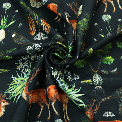 Symmetrical woodland fabric pattern featuring reddish-brown stags with antlers, pinecones, birds, nests with eggs, and botanical flora on a black background.   