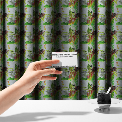 The fabric used to create these made-to-measure curtains is a tropical jungle fabric featuring leopards resting on tree branches alongside pitcher plants, banana leaves, and Monstera foliage on a light grey textured background.