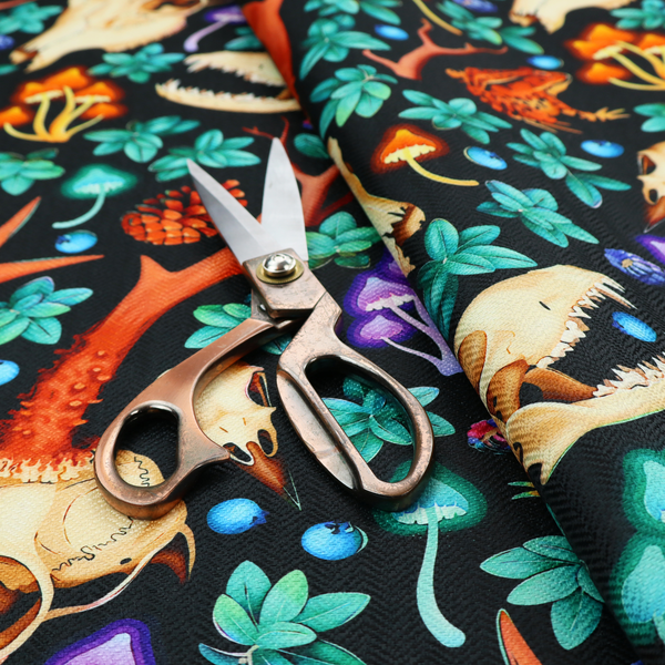 Gothic forest fabric featuring animal skulls with red antlers, bright orange toads, colourful mushrooms, berries, and green foliage on a black background.   