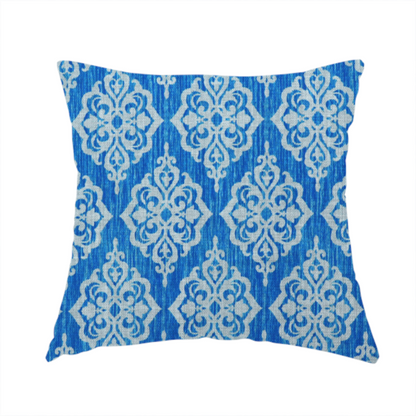 The fabric used to create this handmade cushion is a vibrant royal blue woven fabric featuring an ornate, repeating white damask medallion pattern with a textured ikat effect.   