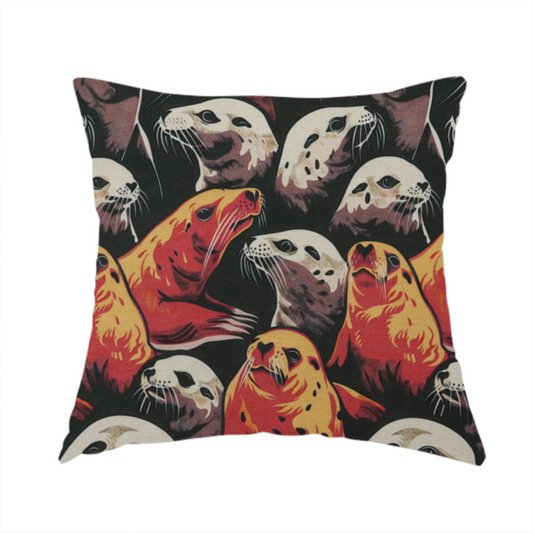 The fabric used to create this handmade cushion is a fabric print featuring a repeating pattern of seals and sea lions in shades of cream, ochre yellow, and coral red on a dark charcoal background.   