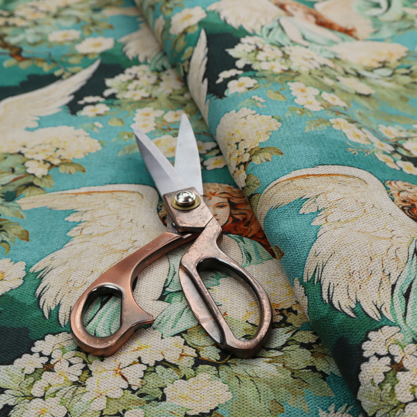 Vintage Victorian style fabric pattern featuring winged angels in sage green gowns surrounded by white blossom branches on a teal and dark forest green background.   