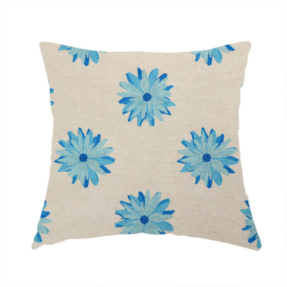 The fabric used to create this handmade cushion is a fabric pattern featuring repeating bright blue daisy-like flowers set against a neutral beige woven background.   