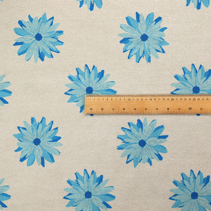 Fabric pattern featuring repeating bright blue daisy-like flowers set against a neutral beige woven background.   