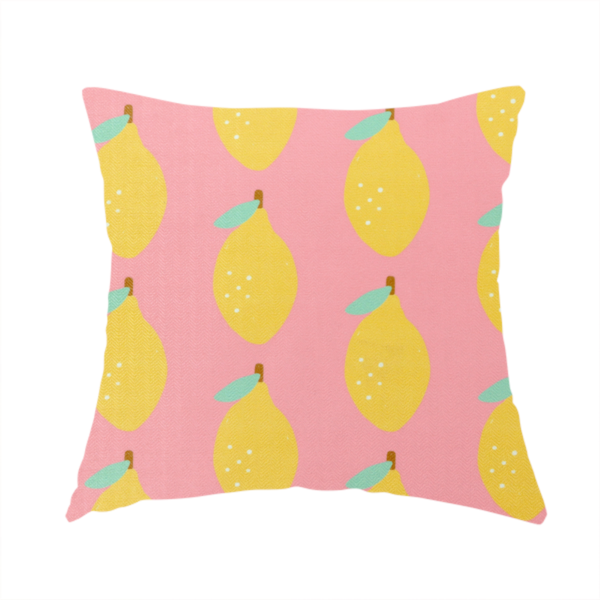 The fabric used to create this handmade cushion is a pink fabric with a repeating pattern of yellow lemons, light green leaves, and small white dots.