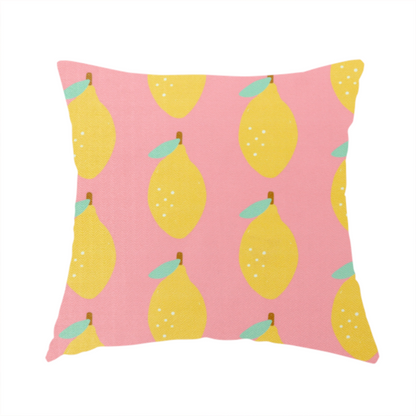 The fabric used to create this handmade cushion is a pink fabric with a repeating pattern of yellow lemons, light green leaves, and small white dots.