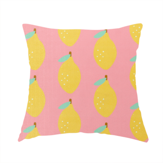 The fabric used to create this handmade cushion is a pink fabric with a repeating pattern of yellow lemons, light green leaves, and small white dots.