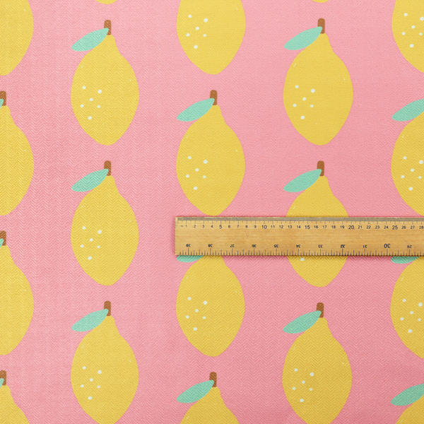 Pink fabric with a repeating pattern of yellow lemons, light green leaves, and small white dots.