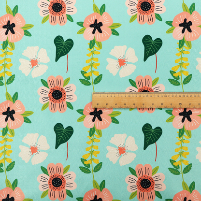 Whimsical floral fabric featuring peach and cream flowers, yellow vining stems, and dark green heart-shaped leaves on a light mint turquoise background.   