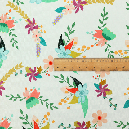 Playful floral fabric featuring scattered colourful bouquets with light blue, coral, purple, and peach blossoms among green stems and mustard foliage on a off-white background.   