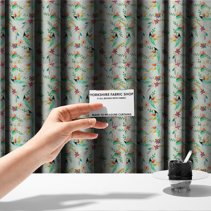 The fabric used to create these made-to-measure curtains is a playful floral fabric featuring scattered colourful bouquets with light blue, coral, purple, and peach blossoms among green stems and mustard foliage on a off-white background.   