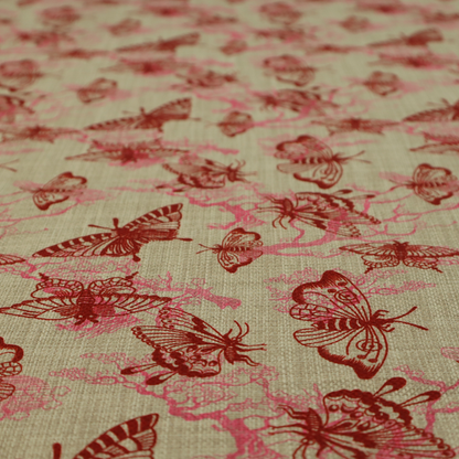 This fabric layers large red butterflies on top of pink tree illustrations, on a neutral background.