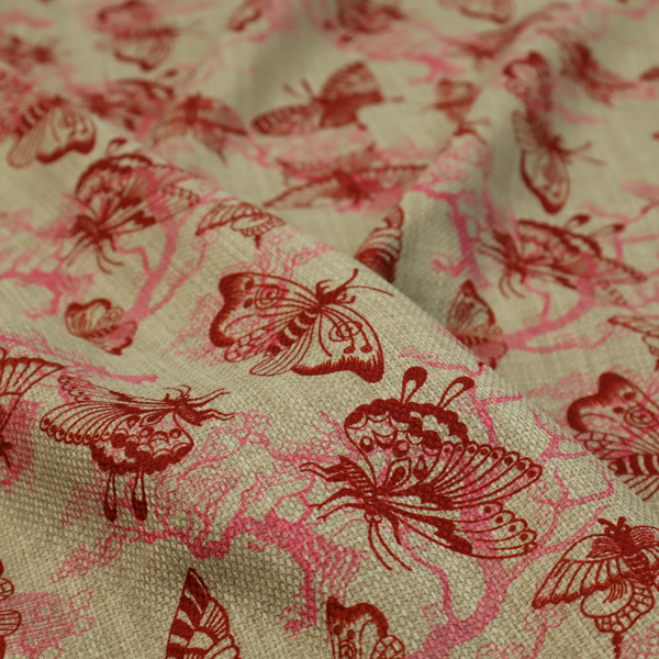 This fabric layers large red butterflies on top of pink tree illustrations, on a neutral background.