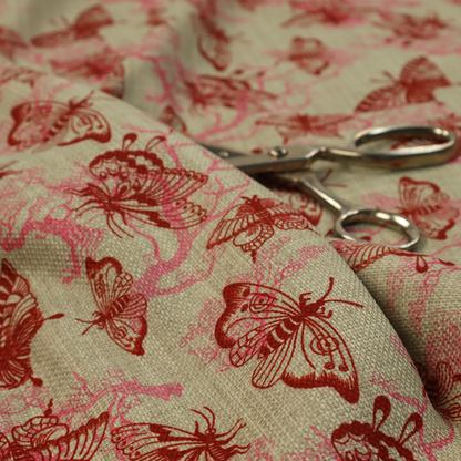 This fabric layers large red butterflies on top of pink tree illustrations, on a neutral background.