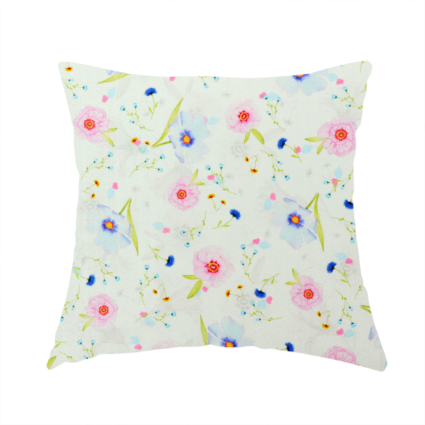 The fabric used to create this handmade cushion is a delicate watercolour floral fabric featuring soft pink poppies, pale blue cosmos, and tiny cornflower buds on a white herringbone-textured background.