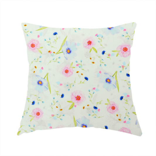 The fabric used to create this handmade cushion is a delicate watercolour floral fabric featuring soft pink poppies, pale blue cosmos, and tiny cornflower buds on a white herringbone-textured background.