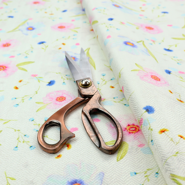 Delicate watercolour floral fabric featuring soft pink poppies, pale blue cosmos, and tiny cornflower buds on a white herringbone-textured background.