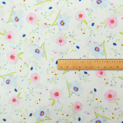 Delicate watercolour floral fabric featuring soft pink poppies, pale blue cosmos, and tiny cornflower buds on a white herringbone-textured background.