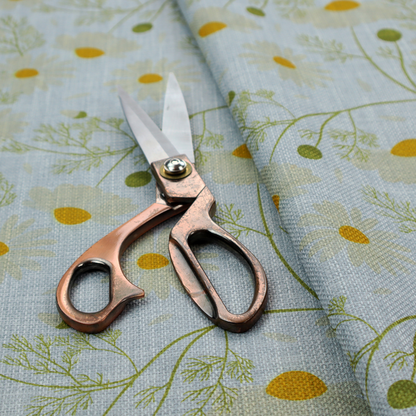 Light blue fabric with a repeating botanical chamomile flower and green foliage pattern