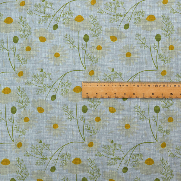 Light blue fabric with a repeating botanical chamomile flower and green foliage pattern