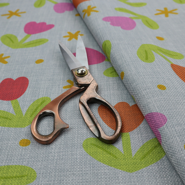 Muted greyish-blue fabric with a whimsical pattern of colourful tulips and small gold accents.