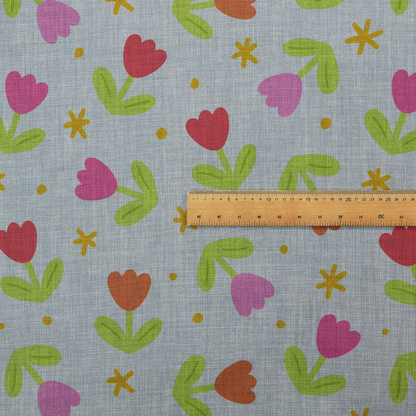 Muted greyish-blue fabric with a whimsical pattern of colourful tulips and small gold accents.