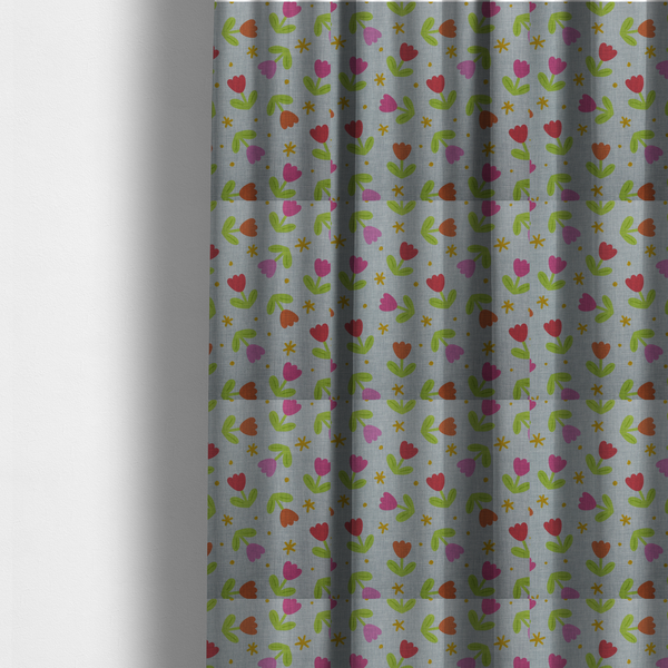 The fabric used to create these made-to-measure curtains is a muted greyish-blue fabric with a whimsical pattern of colourful tulips and small gold accents.