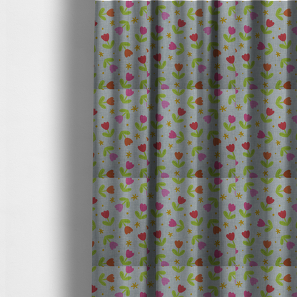 The fabric used to create these made-to-measure curtains is a muted greyish-blue fabric with a whimsical pattern of colourful tulips and small gold accents.