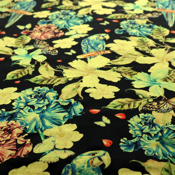 A repeating fabric pattern featuring blue and green parrots, butterflies, and large tropical flowers on a black background.