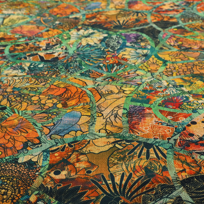 An abstract mosaic fabric pattern with stained glass-style botanical and floral illustrations in emerald green, orange, and gold tones.