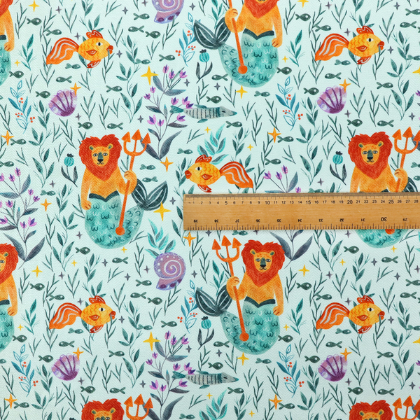 A whimsical fabric pattern featuring orange lion mermaids holding tridents surrounded by fish, sea shells, and ocean flora on a light aqua background.