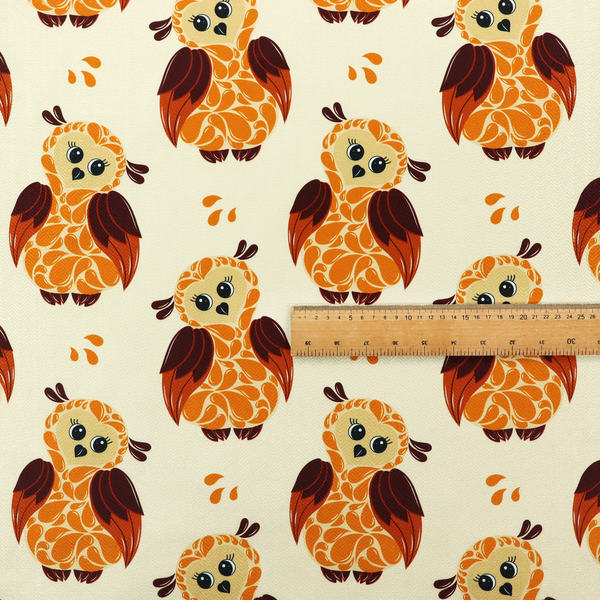 A repeating fabric pattern featuring illustrated owls with paisley-patterned bodies in warm orange, brown, and ochre on a cream background.
