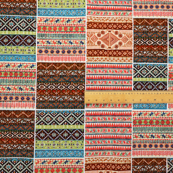Vibrant multi-coloured tribal patchwork fabric featuring geometric and Aztec folk patterns.