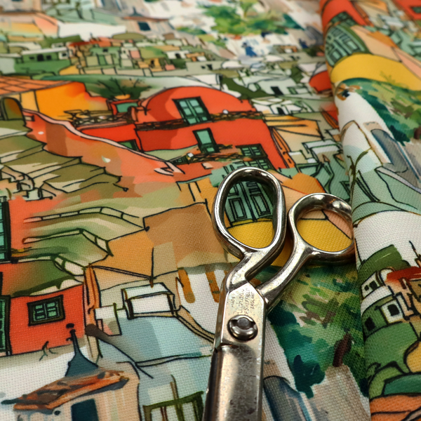 An illustrated fabric pattern featuring a Mediterranean hillside village with terracotta houses, green foliage, and ochre accents