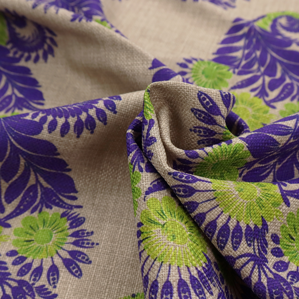 A repeating floral paisley pattern featuring vibrant indigo blue and lime green motifs set against a textured natural beige linen-effect background.