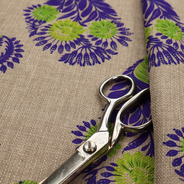 A repeating floral paisley pattern featuring vibrant indigo blue and lime green motifs set against a textured natural beige linen-effect background.