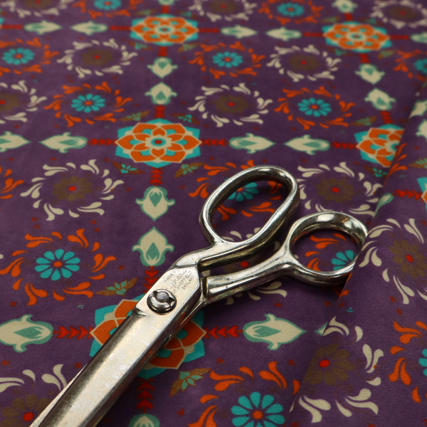 Geometric pattern fabric featuring a purple background with repeating orange and teal mandala-style floral motifs.