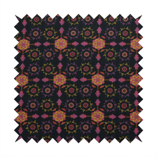 An intricate geometric fabric pattern featuring repeating mandala motifs, floral medallions, and ornate tiles in shades of pink, orange, yellow, and purple set against a dark black background.