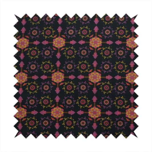 An intricate geometric fabric pattern featuring repeating mandala motifs, floral medallions, and ornate tiles in shades of pink, orange, yellow, and purple set against a dark black background.