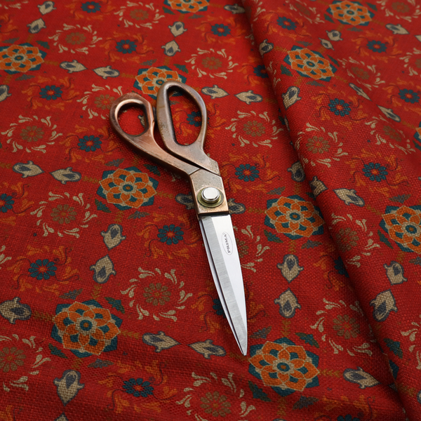 Traditional deep red block-print fabric featuring repeating geometric floral medallions.