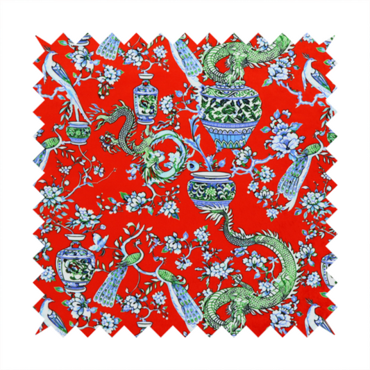 Vibrant red Chinoiseries fabric featuring an intricate pattern of green dragons, elegant peacocks, blue-and-white porcelain vases, and blossoming floral branches.