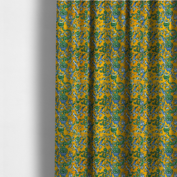 The fabric used to create these made-to-measure curtains is a seamless fabric pattern featuring Chinoiserie-style green dragons, blue and white peacocks, ornate vases, and floral branches against a vibrant mustard yellow background.